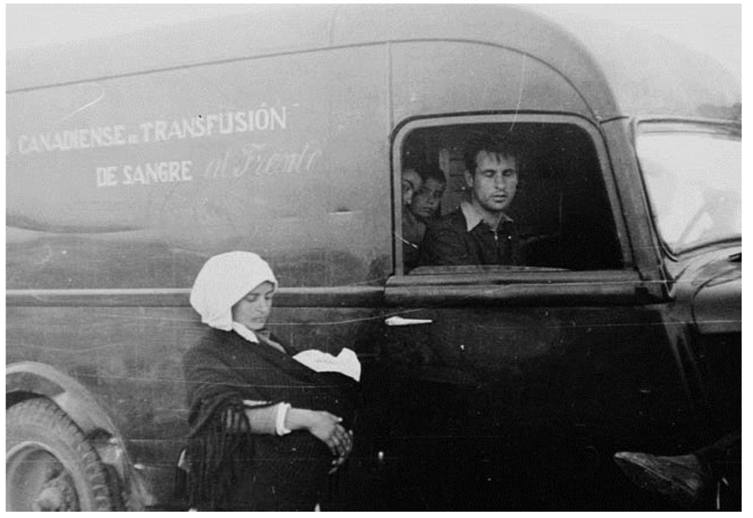 Refugees_beside_an_ambulance_of_the_Canadian_Blood_Transfusion_Unit