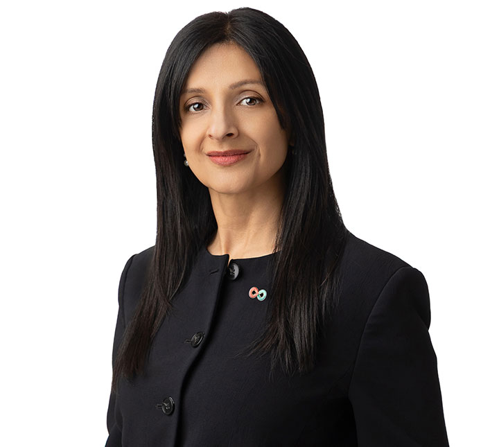 Headshot of women in black vest with long black hair
