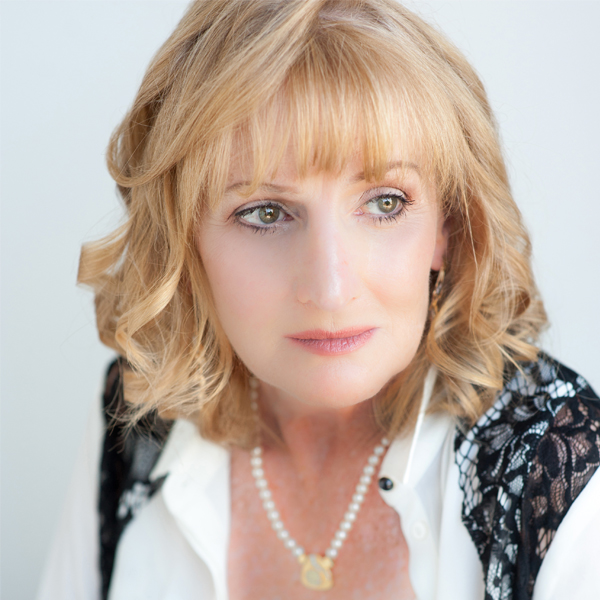 Headshot of Deborah Skaey with medium blonde wavy hair with a white shirt