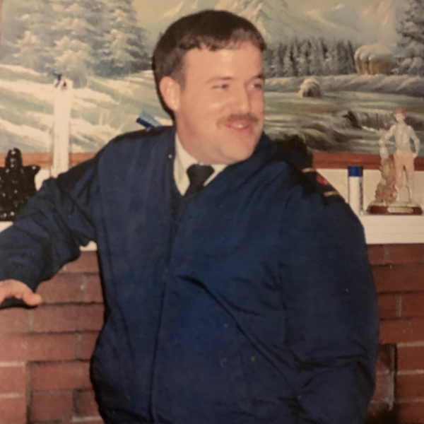 Photo of Robert Sanford standing in front of a chimney in his home