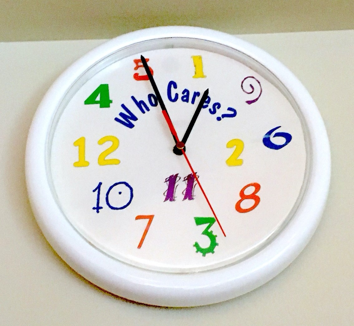 A clock with jumbled numbers and the words "who cares?"
