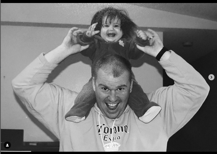 Person holding their baby on their shoulders