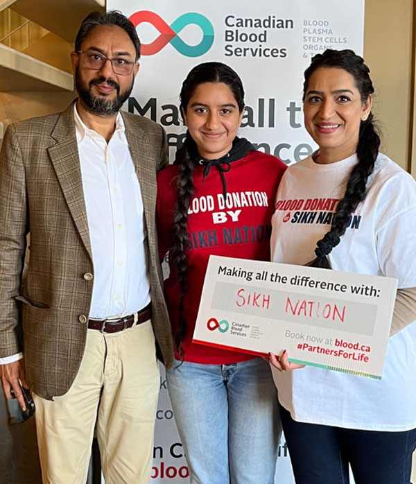 man and two females holding a sign