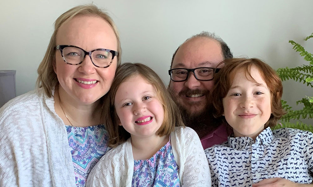 Cord blood donor Dominika Randell and her family smile on their sofa.