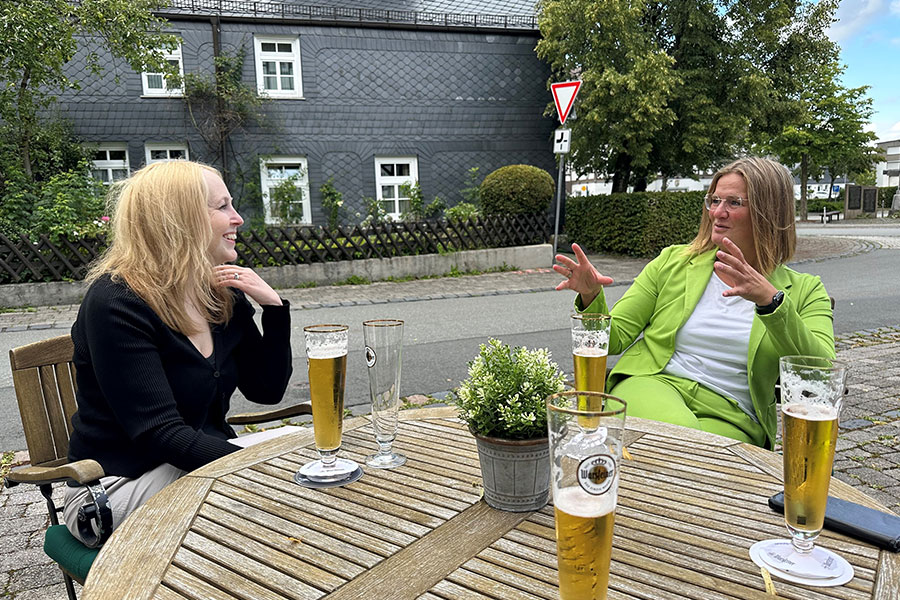 Stem cell donor and stem cell recipient smiling and chatting over beer at a table in the village of Belecke in Germany