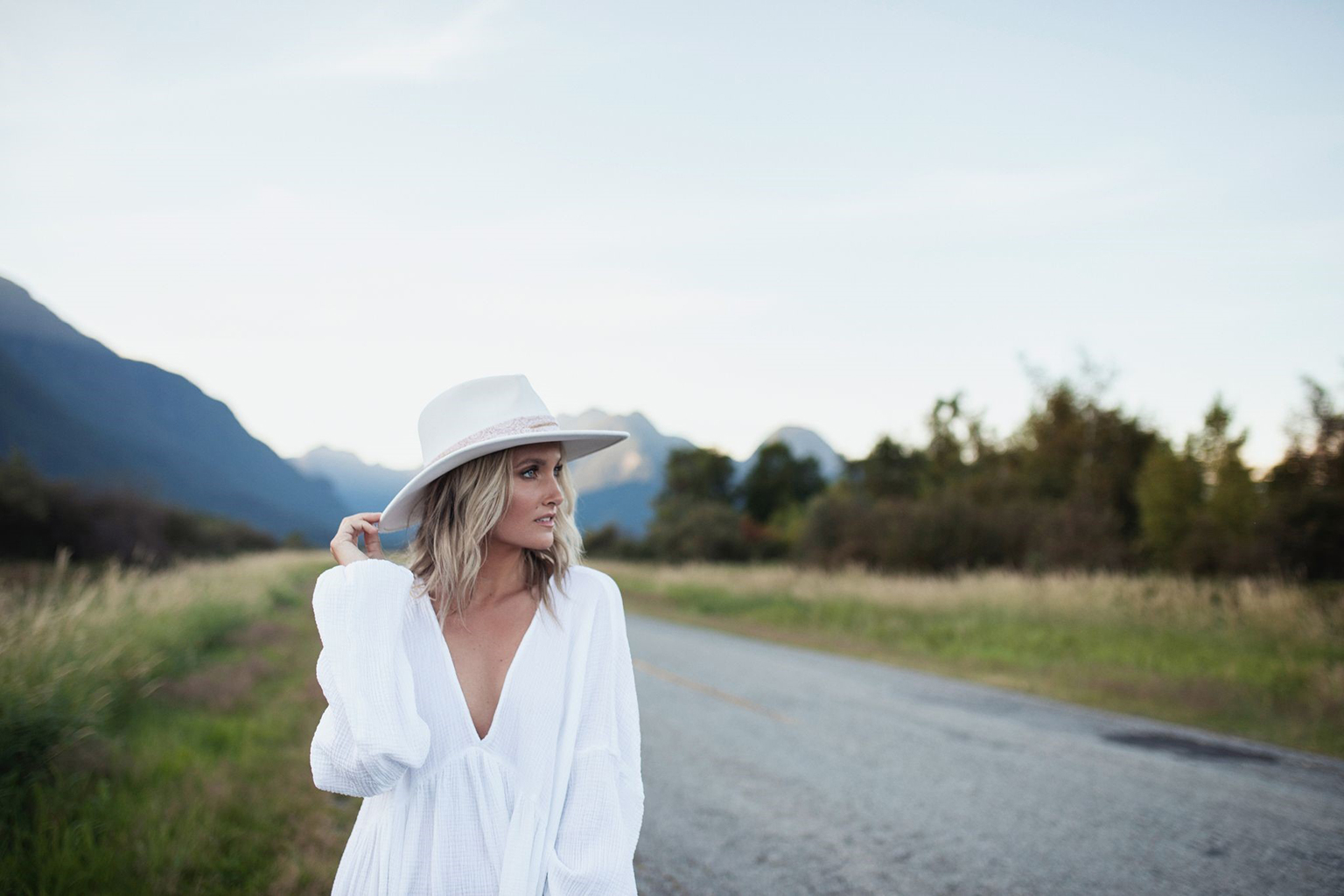 Singer Kalsey Kulyk stands on a road with a backdrop of mountains behind her. She performed at Canadian Blood Services’ Honouring Canada’s Lifeline virtual event.