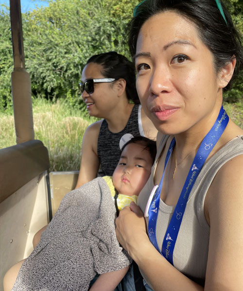 Mère berçant son enfant sur ses genoux lors d’un circuit dans un parc d’attractions Disney.