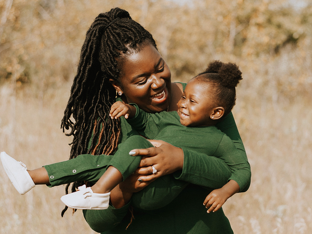 Blood recipient Amelie Bangamba is carried by her mom Leslie.
