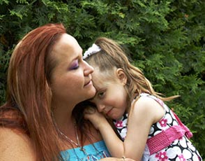 Madison - Blood Recipient Young girl leaning on her mother's shoulder outside