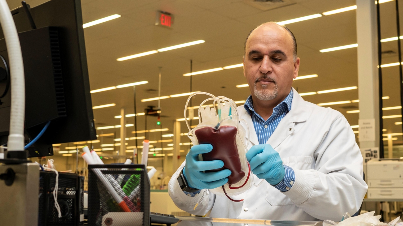 An employee at Canadian Blood Services receives donated blood.