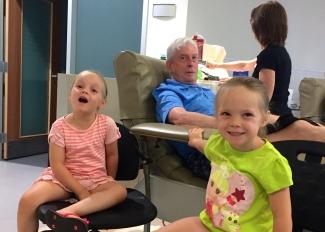 Brian Boyd donates blood with his twin granddaughters Lillian and Violet Boyd.