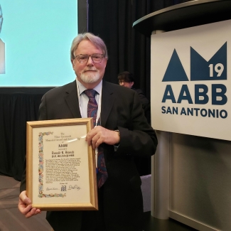 Dr. Donald Branch holds his award at the AABB annual meeting in San Antonio