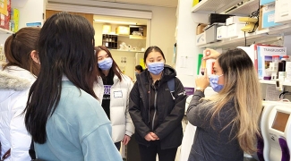 Students wearing masks taking a tour of a research lab