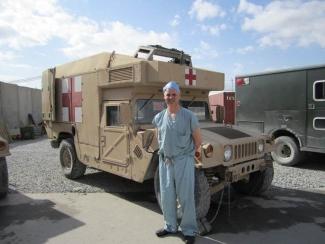 Image of Dr. Andrew Beckett standing beside military ambulance
