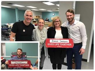Peacock Sheridan Group at a donor centre posing together and hoping up a Gives Life Together sign.