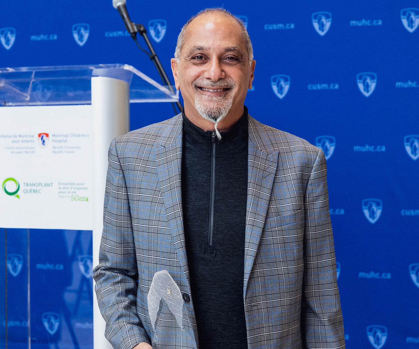 Dr. Sam Shemie posing for camera holding the Grand Prix award.