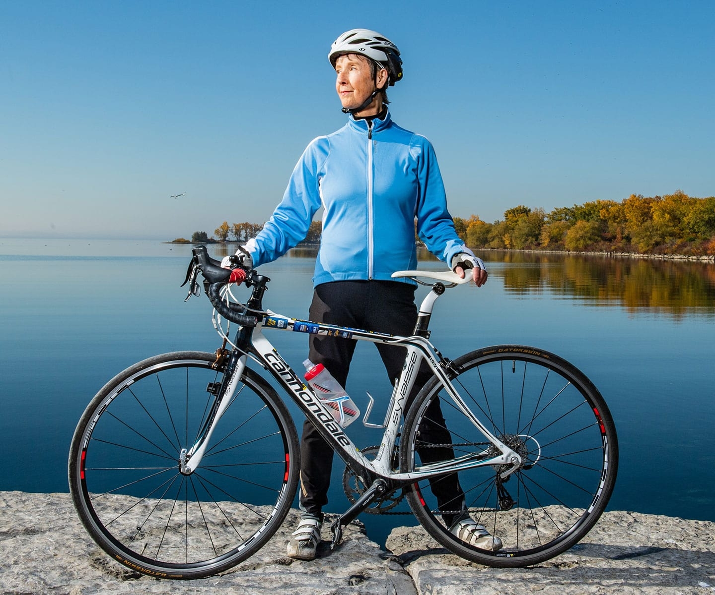 Une greffée de cellules souches avec son vélo de course sur un rocher au bord de l’eau