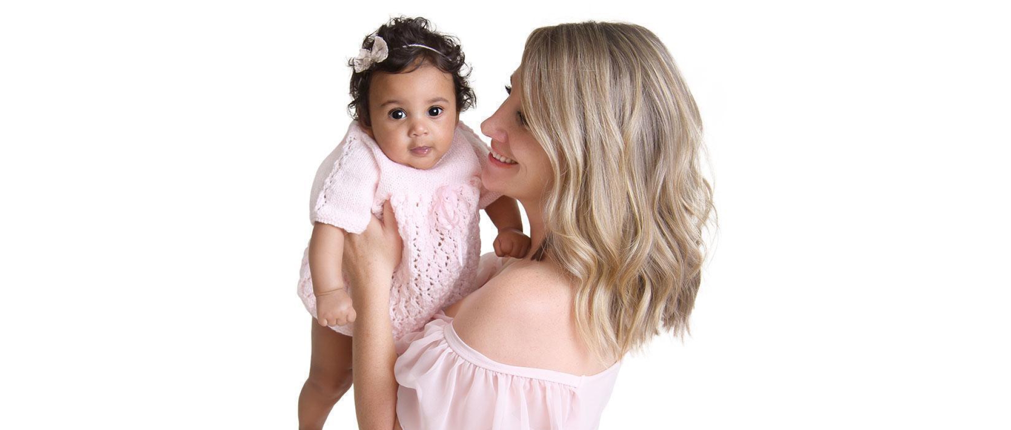 Jessica and her baby on a white background wearing pink