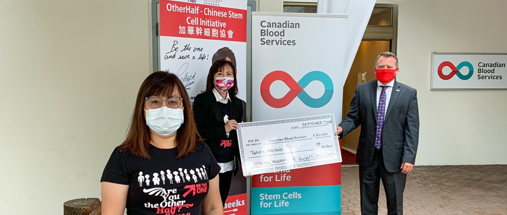 Image of Representatives of OtherHalf - Chinese Stem Cell Initiative holding up a giant cheque of $20,000 to Canadian Blood Services