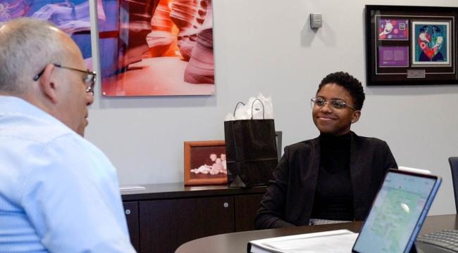 Young woman and CEO mentor facing each other in office