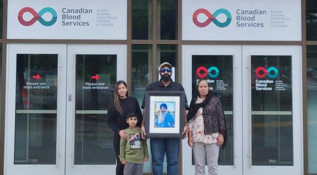 Bunvir Kaur and her family with a photo of her father outside the plasma donor centre in Kelowna, B.C. 